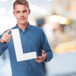 Mężczyzna uśmiecha się na literę "L"