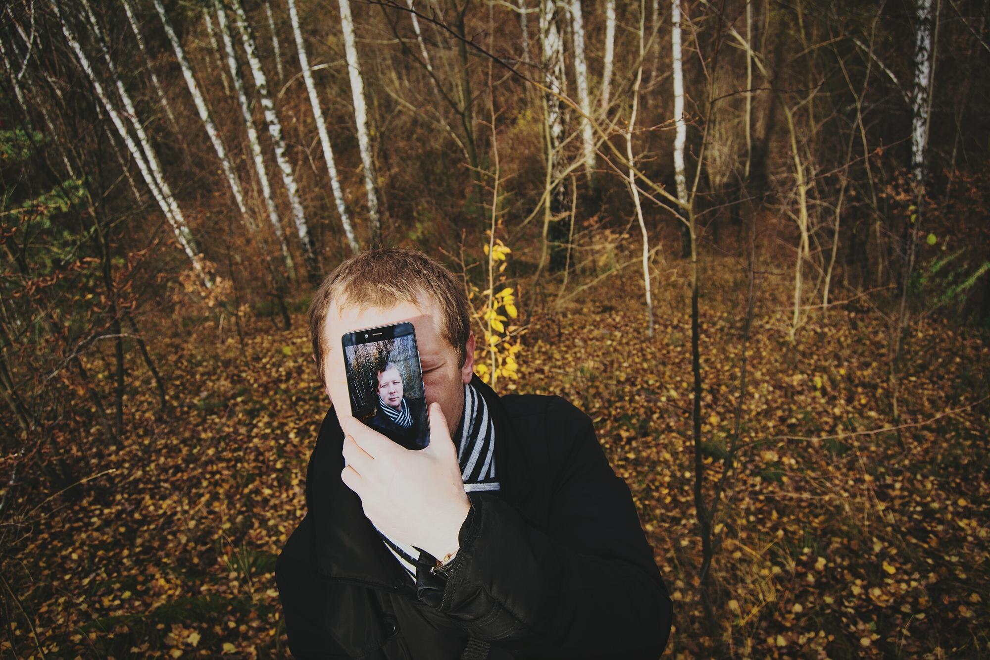 Mężczyzna fotografuje telefonem komórkowym