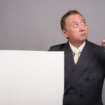 Portret dojrzałego biznesmena azjatyckich przeciw szarej ścianie