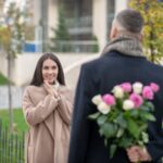 Bardzo podekscytowana kobieta patrzy na swojego chłopaka, czekając na prezent od niego