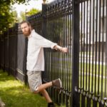 Cała długość człowieka stojącego przy ogrodzeniu