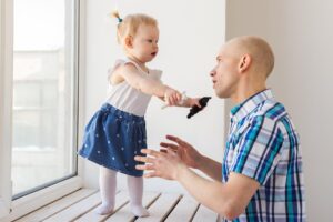 Widok boczny ojca i córki stojących na podłodze