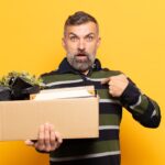 Dorosły mężczyzna wyglądający na zszokowanego i zaskoczonego z szeroko otwartymi ustami, wskazujący na siebie