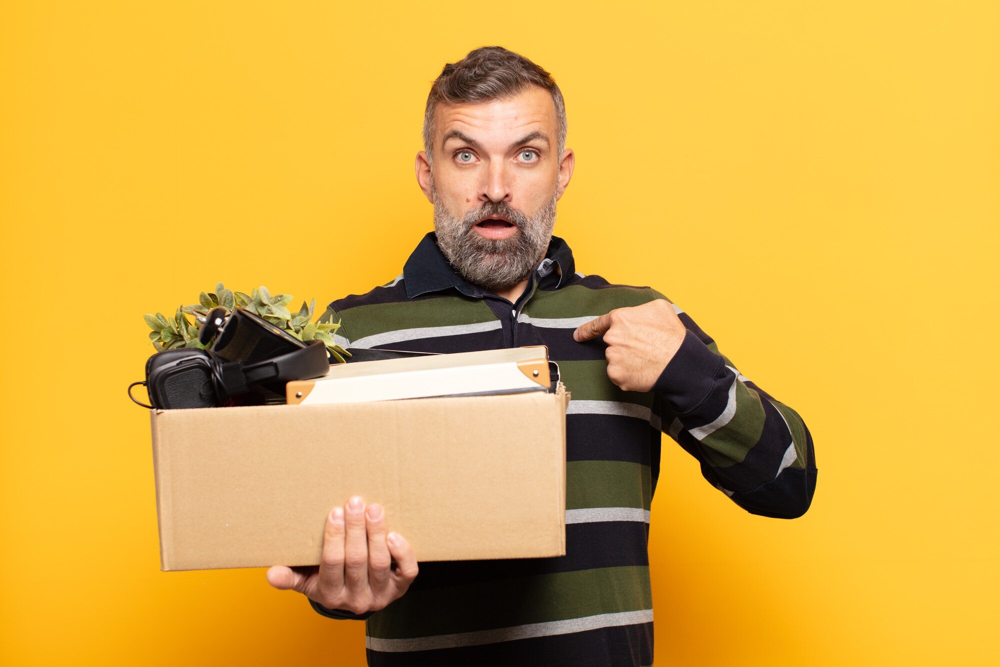 Dorosły mężczyzna wyglądający na zszokowanego i zaskoczonego z szeroko otwartymi ustami, wskazujący na siebie