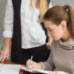 Kobiety biznesmenki pracujące przy stole przy ścianie