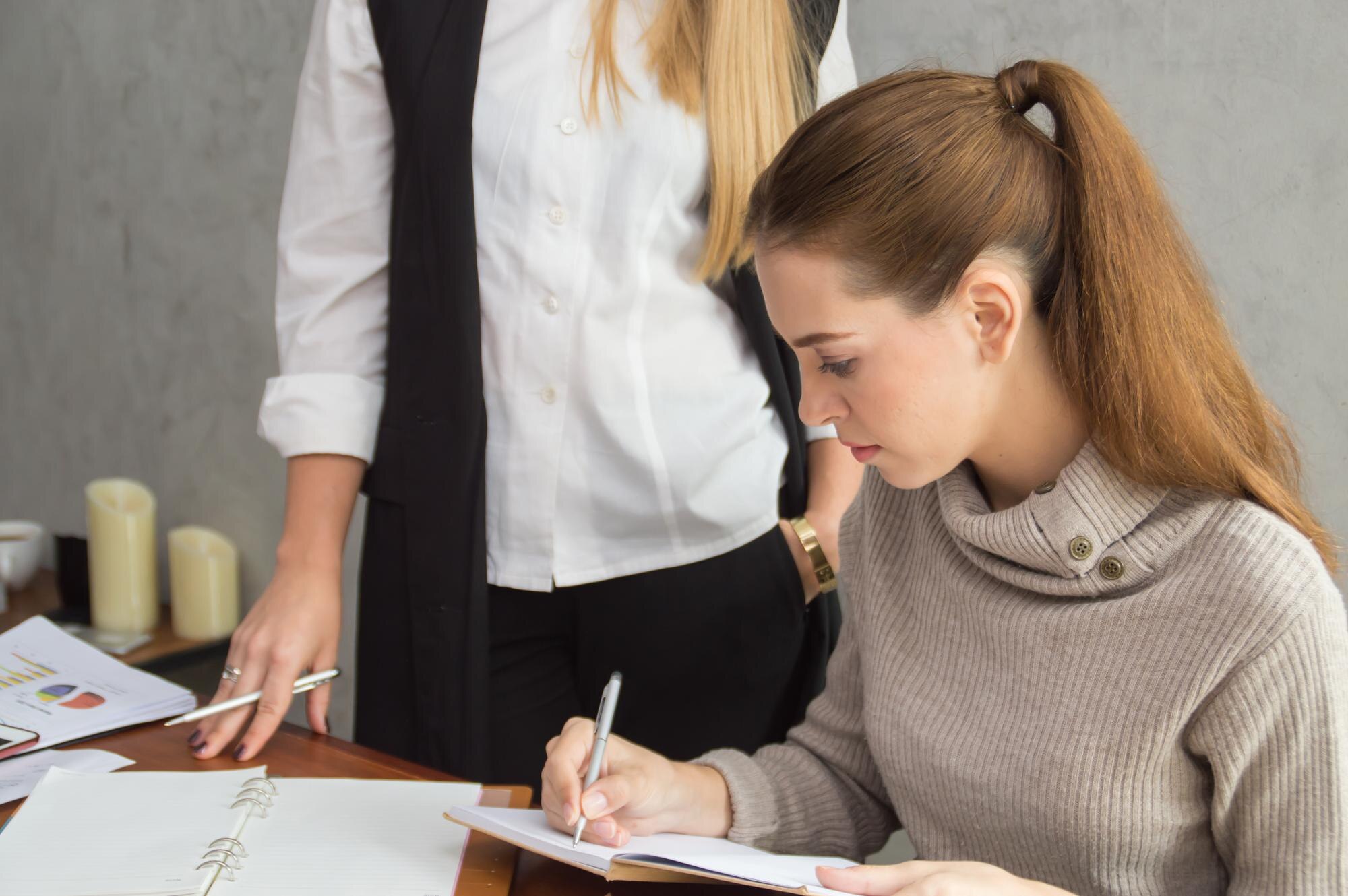 Kobiety biznesmenki pracujące przy stole przy ścianie