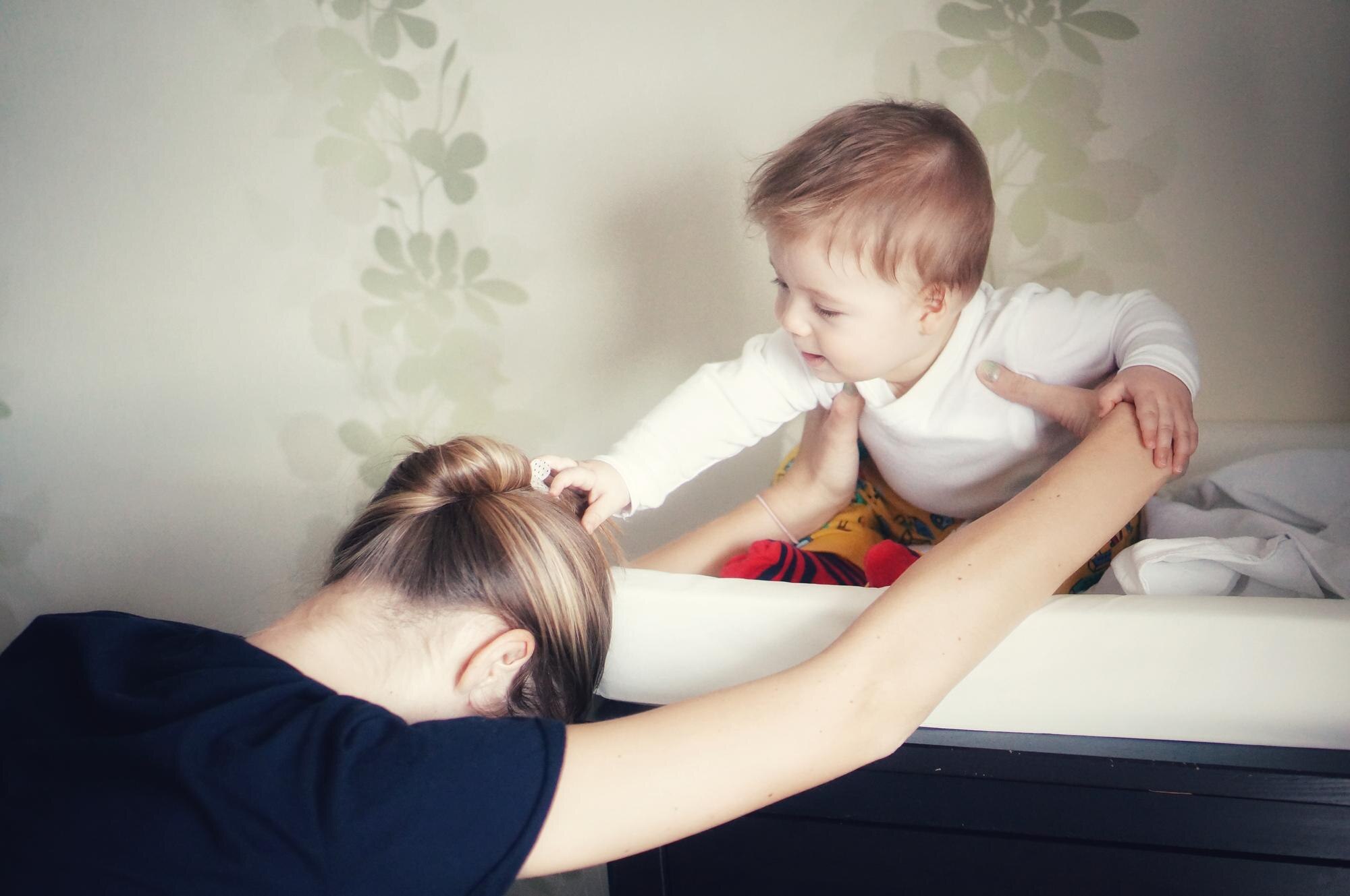 Mama bawi się z uroczym chłopcem w domu.