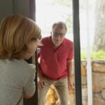 Dziadek i wnuk bawiący się w kryjówkę w wygodnym domu