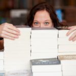 Kobieta w księgarni i stos na stole w portrecie z ukrytą twarzą do sprzedaży zniżkowej i promocji Przedsiębiorca biblioteka i tajemnica dla sprzedaży detalicznej literatury i wiedzy do uczenia się w sklepie