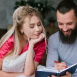 Uśmiechnięta para robienia notatek na notatniku