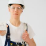 Młody elektryk na białej ścianie