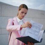 Elegantny dyrektor czyta raport na ulicy, bizneswoman sprawdza dokumenty.