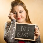 Portret smutnej kobiety trzymającej tablicę z zaznaczoną negatywną odpowiedzią