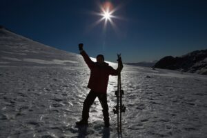 Sylwetki mężczyzna dźwigania ręka z narty deską na śniegu