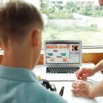Zbliżenie nauczyciela podnoszącego przewody, podczas gdy chłopiec patrzy na instruktora