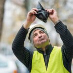 Inżynier w odblaskowej odzieży patrzący na portfel