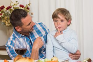 Ojciec z synem siedzi na kolanach