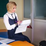 Wesoła kobieta uczy angielskiego w klasie w pobliżu tablicy. Nauka angielskiego. Koncepcja edukacji.