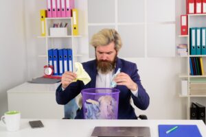Brodaty biznesmen z koszem na śmieci pomysły biznes biuro mężczyzna w biurze