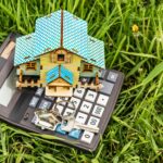 Pojęcie hipoteki i wynajmu mieszkań i nieruchomości. Kredyty hipoteczne. Układ domu z kalkulatorem na kwitnącej łące. Kupowanie mieszkań przyjaznych środowisku.