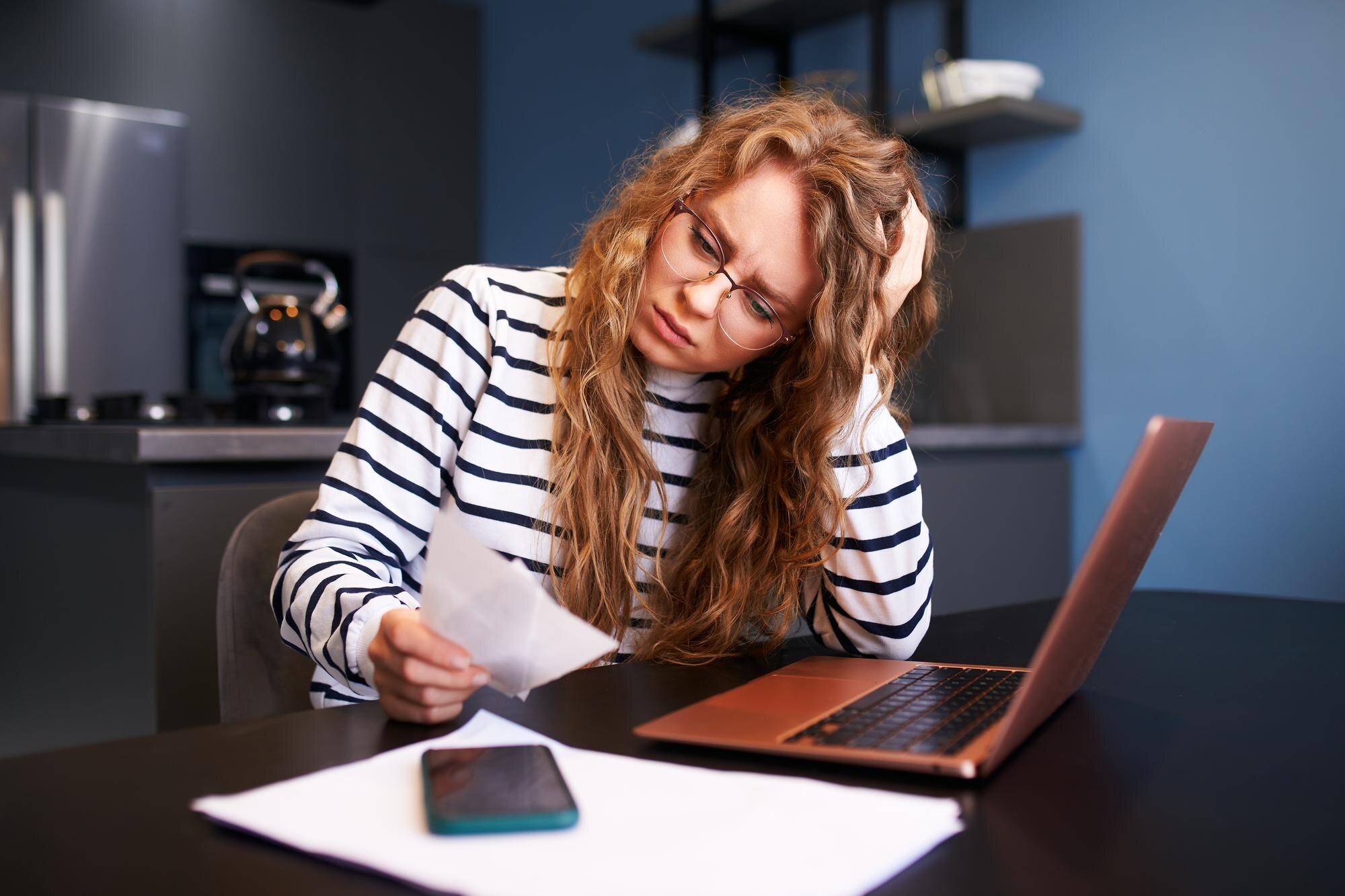 Nieszczęśliwa kobieta oblicza wydatki na rachunki, zdenerwowana wzrostem cen usług publicznych, kobieta licząca wypłaty, długi, pożyczki, przychody do płacenia podatków, kryzys finansowy, inflacja, niska zdolność płatnicza.