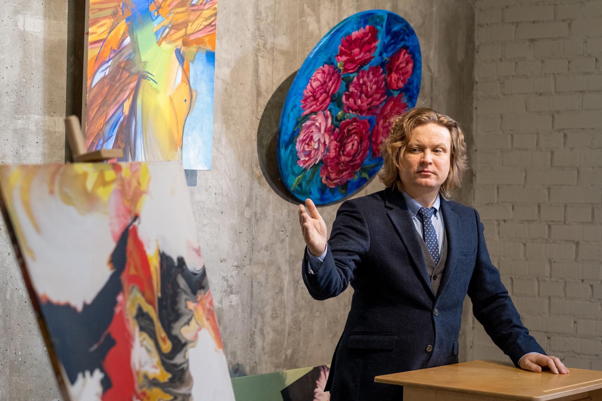 Pewny siebie dojrzały mężczyzna w eleganckim garniturze stojący przy trybunie