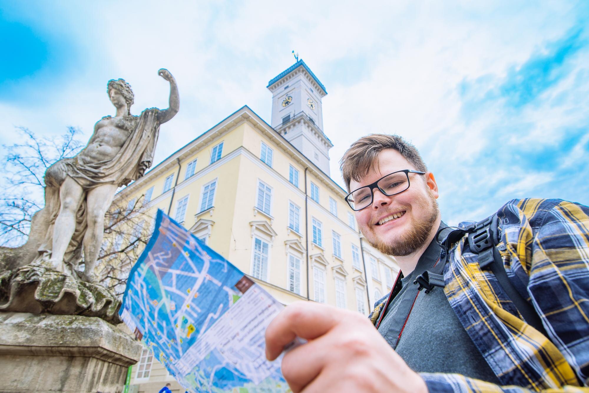 Młody dorosły turysta z kamery i plecaka oglądać mapę. koncepcja podróży. kopiuj przestrzeń