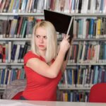 Przystojna studentka rzucająca laptopem i chce go zniszczyć