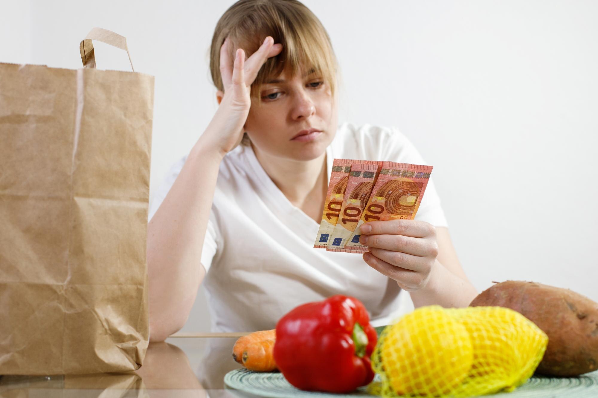 kobieta liczy pieniądze po zakupie produktów