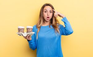 Ładna kobieta wygląda na zaskoczoną, realizując nowy pomysł na myśl lub koncepcję zabrania koncepcji kawy