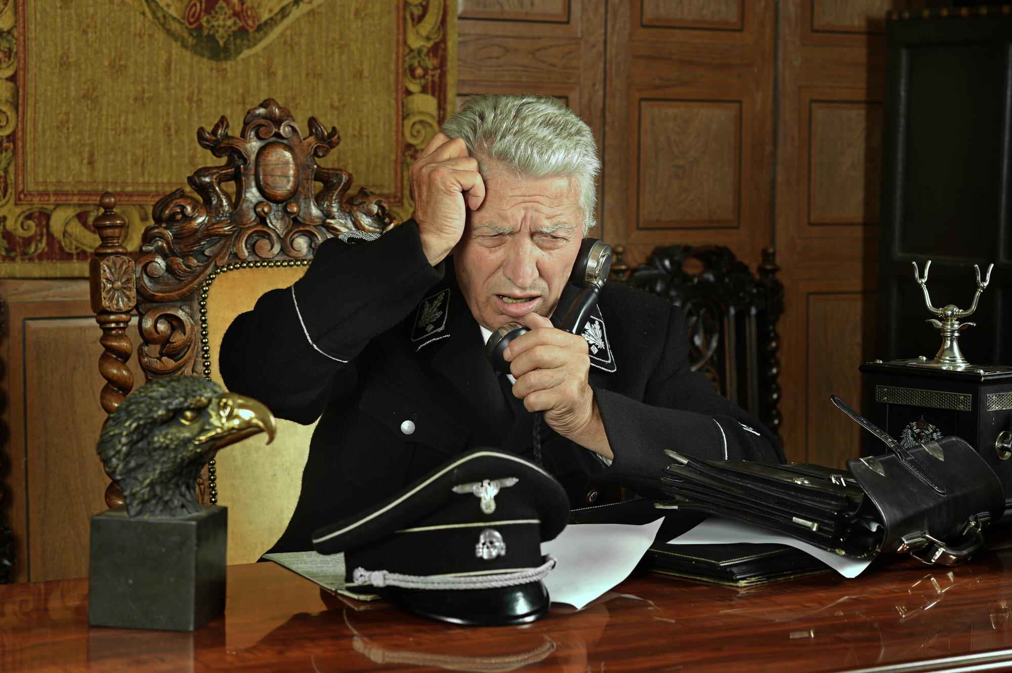 Dojrzały generał wojskowy dzwoni przez telefon w swoim biurze