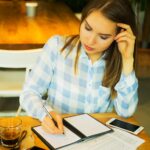 Zbliżenie młodej pięknej kobiety biznesu pisania w notatniku