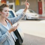 Zna się na mieście Wykadrowane ujęcie młodej bizneswoman gestykulującej, by złapać taksówkę w mieście