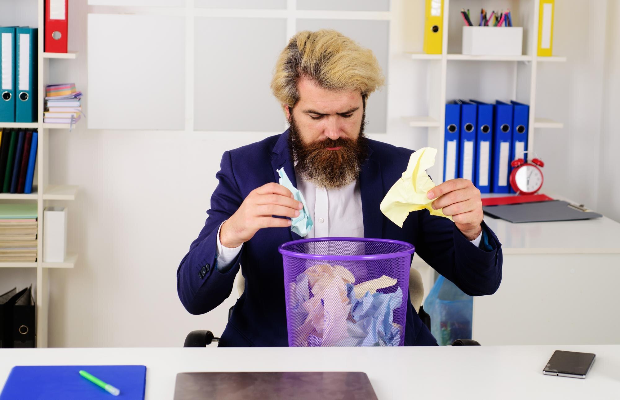 Brodaty biznesmen z koszem na śmieci pracownik biurowy z koszem na śmieci dyrektorem ds. recyklingu papieru biznesowego