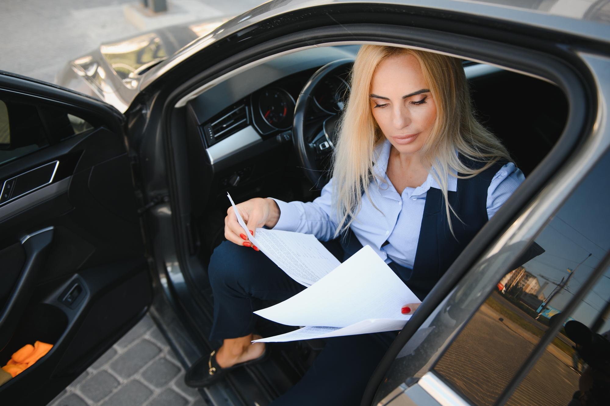 Portret biznesowej eleganckiej kobiety w średnim wieku w samochodzie