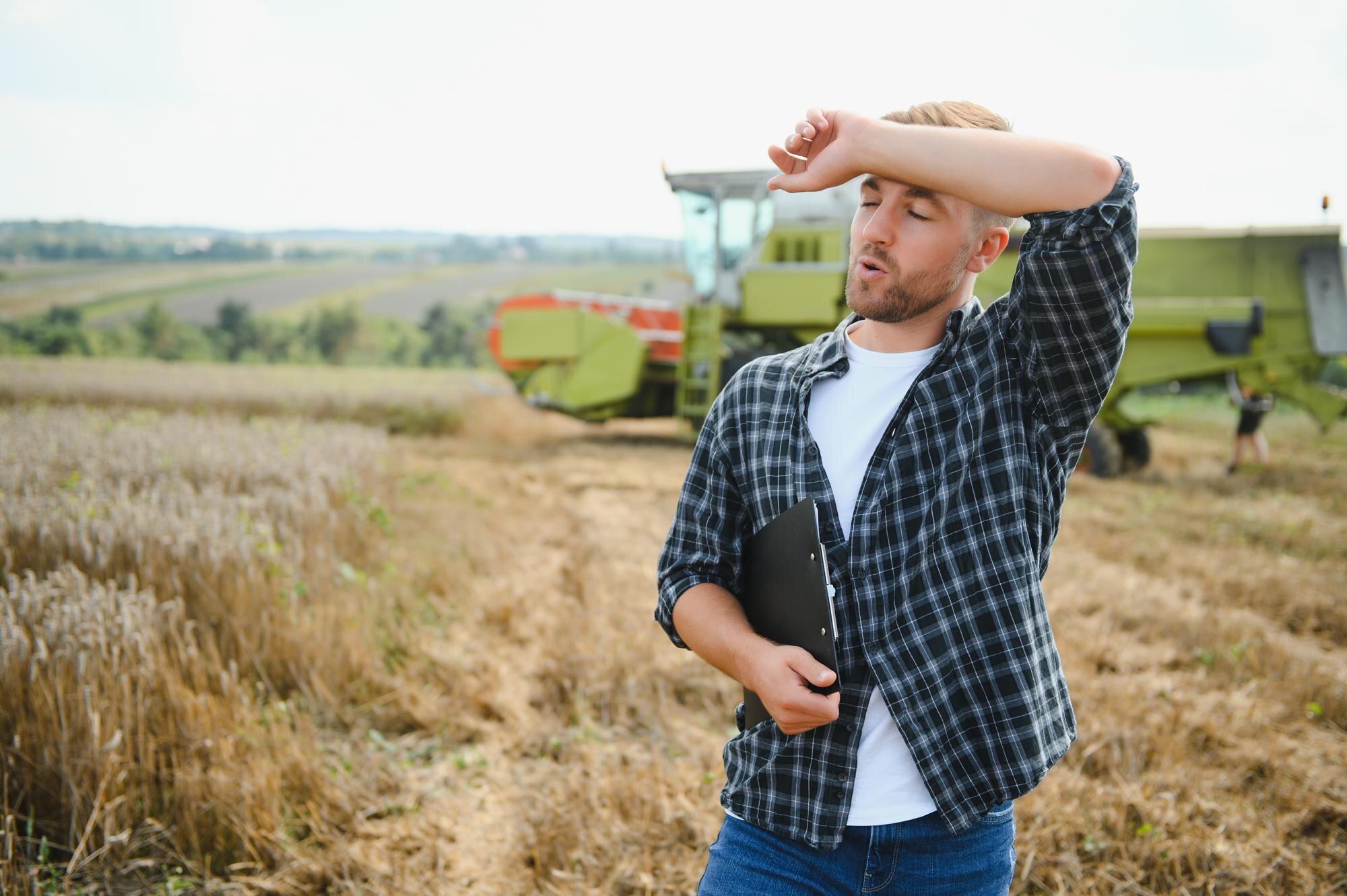 Szczęśliwy rolnik dumnie stojący na polu Kierowca kombajnu zamierza skosić bogate zbiory pszenicy Agronom w flanelowej koszuli patrzący na kamerę na polu uprawnym