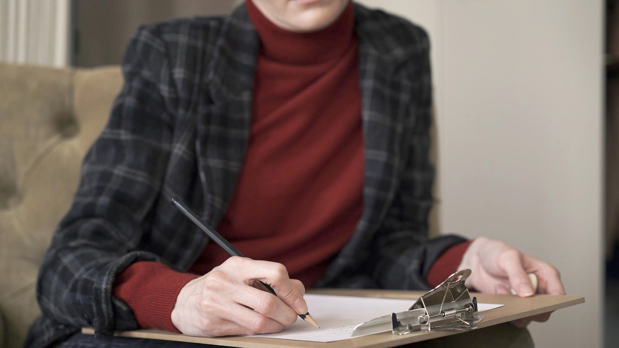 Kobiece ręce kierownika na krześle robienia notatek w papierze trzymającym ołówek