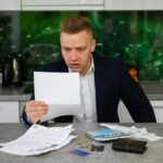 Mężczyzna czyta powiadomienie dotyczące opóźnionych płatności