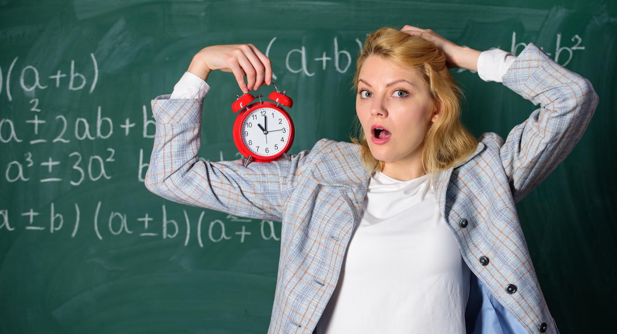 Dba o dyscyplinę Nauczycielka trzyma budzik Koncepcja harmonogramu lekcji Czas na przerwę Czas ma dla niej znaczenie Powitanie nauczyciela w roku szkolnym Zdrowy reżim dzienny Wychowawca rozpoczyna lekcję