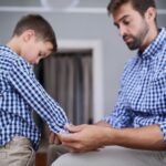 Ojciec i dziecko pomagają przygotowywać się rano do rozpoczęcia szkoły z wsparciem wzrostu lub rozwoju w domu Sypialnia ojciec i syn wiążą koszulę do ubierania rutyny z miłością opieki i pasujących ubrań