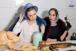 Dwie kobiety siedzą przy stole z świnią na stole.