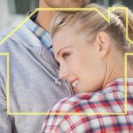 Modna młoda para przytulająca się przed zarysem domu