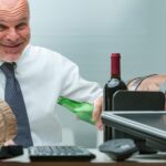 Mężczyzna wyglądający na głupca nadmiernie pije alkohol w biurze przytłaczająca scena z beczkami