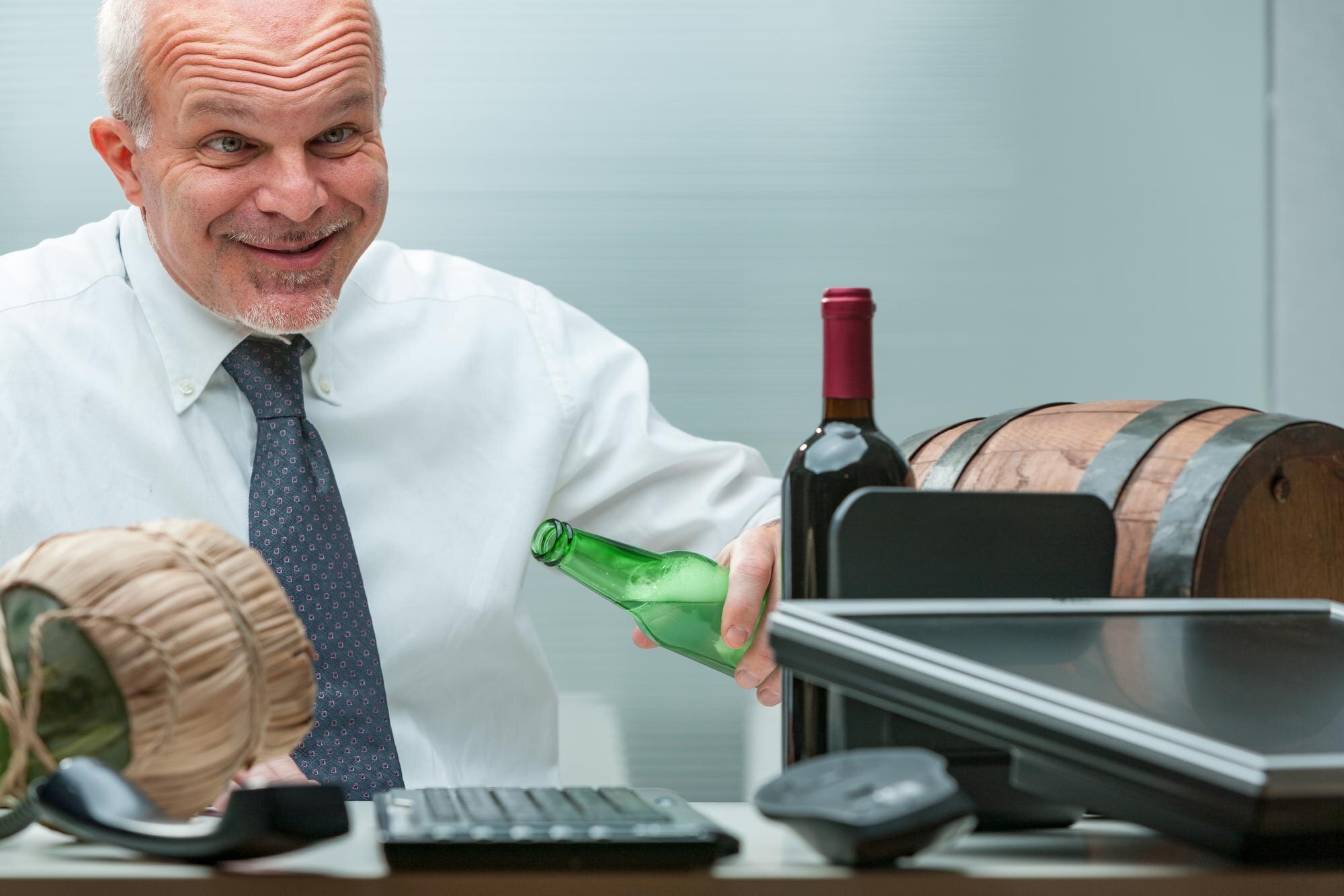 Mężczyzna wyglądający na głupca nadmiernie pije alkohol w biurze przytłaczająca scena z beczkami