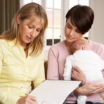 Matka z nowo narodzonym dzieckiem rozmawia z lekarzem w domu