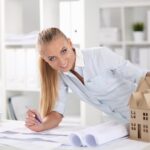 Portret kobiety architekta z projektami przy biurku w biurze