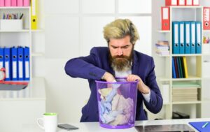 Odzyskiwanie plików po usunięciu Szpieg biurowy Kopanie w śmieciach Przebranie przez papiery Pracownik biurowy kopanie śmieci Odzyskiwanie dokumentów Biznesmen trzyma śmieci Człowiek szuka utraconego dokumentu