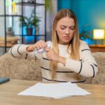 Biała kobieta sfrustrowana błędnymi rachunkami w domu na stole trzymając dokumenty czując się bankrutem