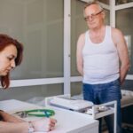 Profesjonalna lekarka pokazująca wynik testu medycznego wyjaśniająca receptę za pomocą aplikacji na tablet cyfrowy odwiedzająca starszego mężczyznę pacjenta w domu siedzącego na kanapie Starsi ludzie koncepcja technologii opieki zdrowotnej