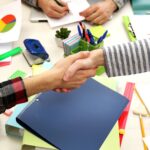 Grupa ludzi pracujących przy biurku z widokiem z góry